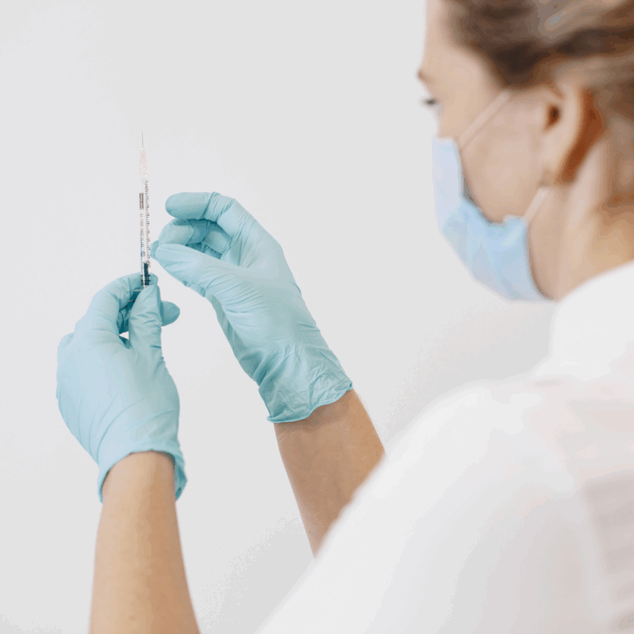 na zdjęciu znajduje się pielęgniarka ze strzykawką